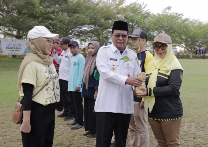 Paman Birin memberikan bibit dan mengucapkan terimakasih sudah peduli lingkungan ucapkan terimakasih