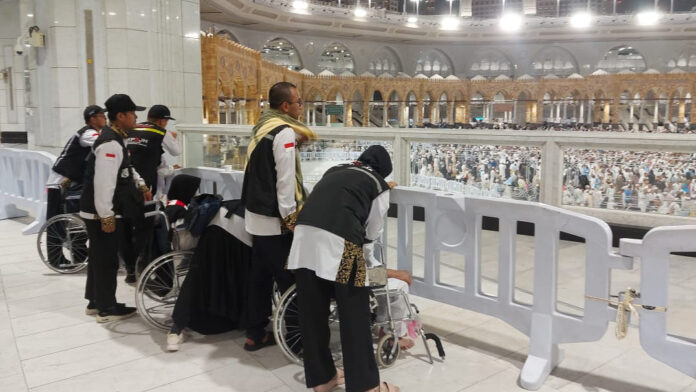 tiga jemaah difasilitasi berdoa di depan ka'bah depan ka'bah